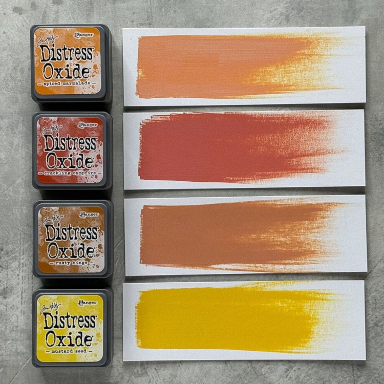 Cztery kolory tuszu Distress Mini Oxide z zestawu Kit 2: Spiced Marmalade, Crackling Campfire, Rusty Hinge i Mustard Seed ułożone razem