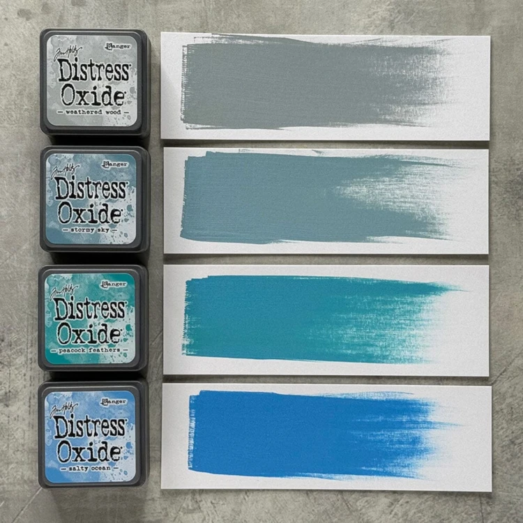 Cztery kolory tuszu Distress Mini Oxide z zestawu Kit 4: Weathered Wood, Stormy Sky, Peacock Feathers i Salty Ocean ułożone razem