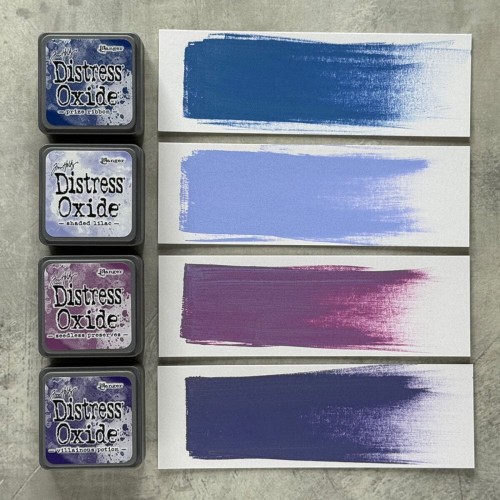 Cztery kolory tuszu Distress Mini Oxide z zestawu Kit 5: Prize Ribbon, Shaded Lilac, Seedless Preserves i Villainous Potion ułożone razem